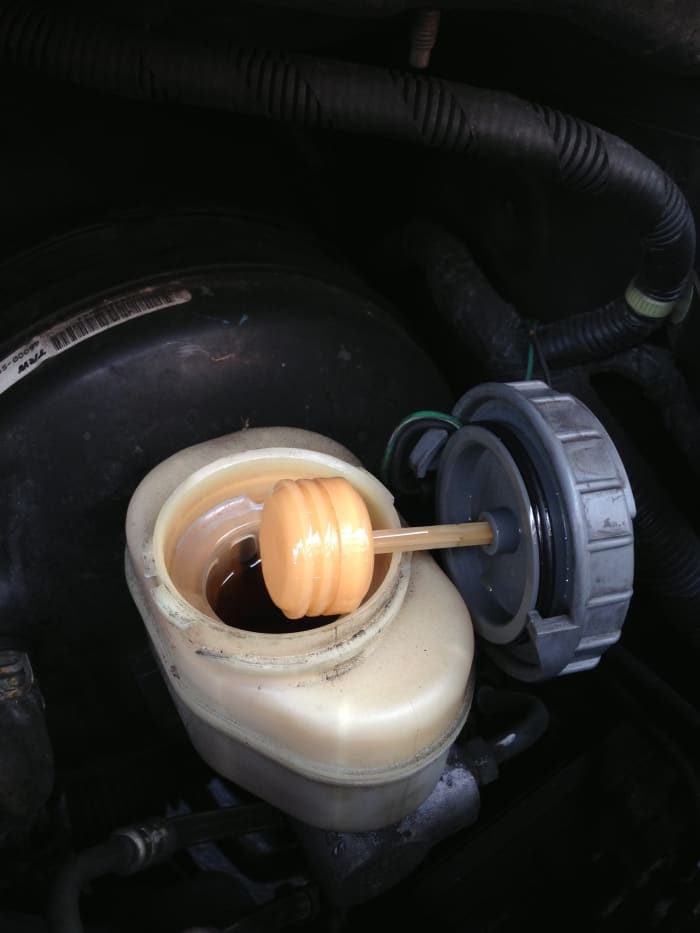 Peering inside the reservoir lets you check fluid-condition. It may look "dark" in the reservoir, but shining a flashlight inside or pulling a sample will confirm.
