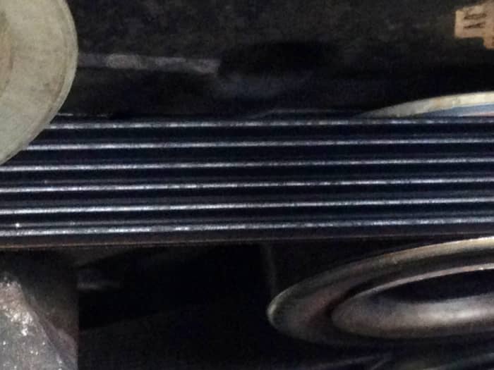 The accessory/"serpentine" belt on this engine was changed recently (when its timing belt was replaced). Both are typically changed together (so an accessory belt with cracks may indicate something more dangerous – a wearing timing belt behind it).