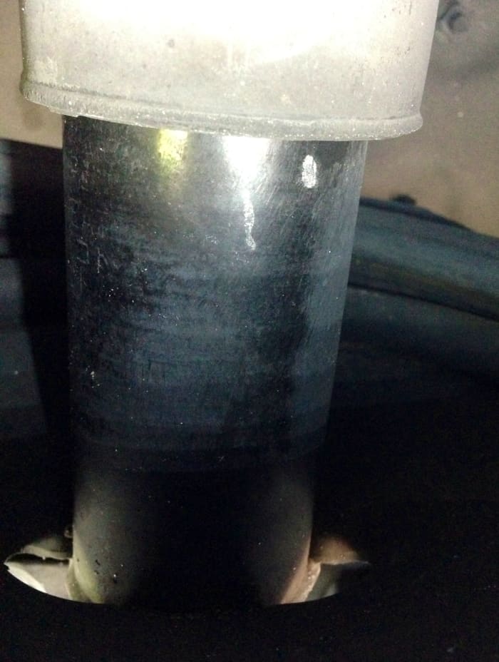A badly worn shock/strut makes for laughably-bad handling that's no joke. Check for oil leaking from where the two halves compress into each other (a dead giveaway of a dead part). The light I used makes it shiny, but this shock is dry-as-a-bone.