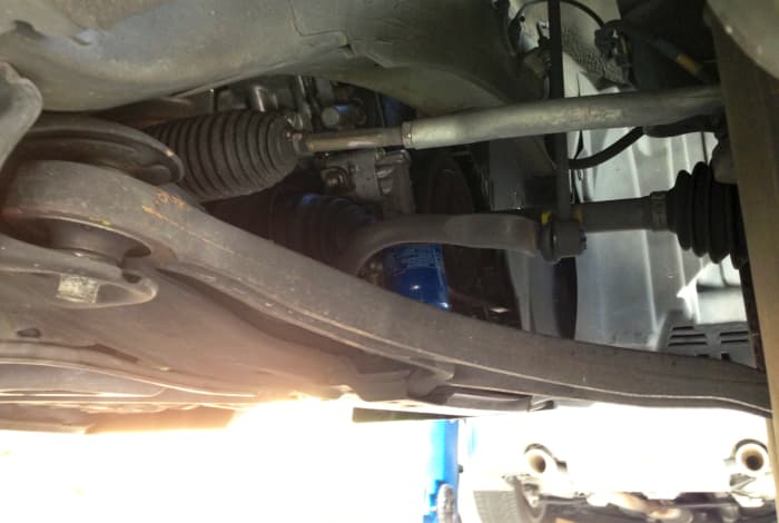Easier on "tall" cars like this S.U.V., looking at major suspension parts like the axles and certain bushings give you an idea of how the whole system is doing. Watch for torn rubber bits and signs of grinding/rubbing.