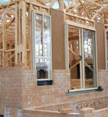 On this low-set brick-veneer the bricklayers have started constructing the brick veneer outside. it is a good photo to show the construction here, but what seems to be missing is the insulating building paper that is nailed to the timber frame.