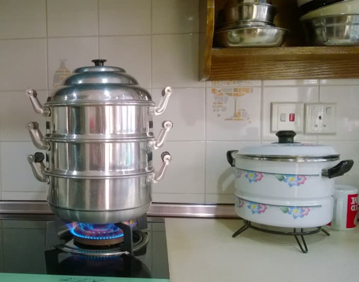 2-Tier Steamer (left) the bottom tier is a container for boiling water. Above are 2 steaming trays. A Combined Steamer (right) is a pot with ridges on the sides to hold a perforated tray for steaming food. Water is placed inside the pot.