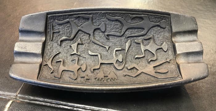 This is a Coco Joe's mid-century ashtray made in Hawaii from lava. It has Hawaiian dancers and symbols on the front. Ashtray measurments 6 1/2” long 3” wide 1 1/4” tall.