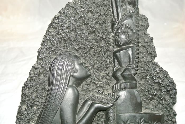 This beautifully made Coco Joe’s wall hanging is about 12 1/4 inches tall and about 7 inches wide. This shows a young Hawaiian women giving an offering to her Tiki for help and protection.