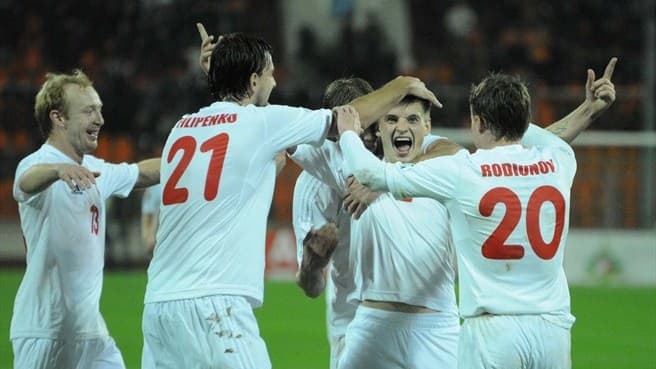 Yahor Filipenko (21) and Vitali Rodionov (20) celebrate with Stanislav Drahun during a 2014 World Cup match in October 2012.