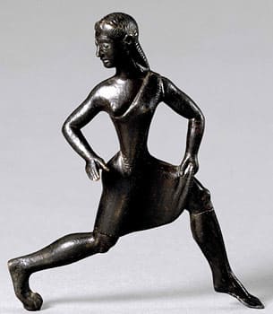 Bronze statuette of a girl wearing a short tunic. The single-shouldered garment, baring the right breast, was the characteristic dress of competitors in the Heraean Games.