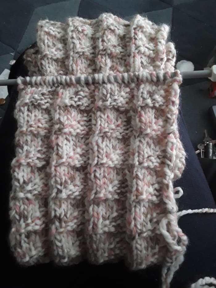 flag stitch scarf which is still in progress. It has been folded and needle is at the top of the work