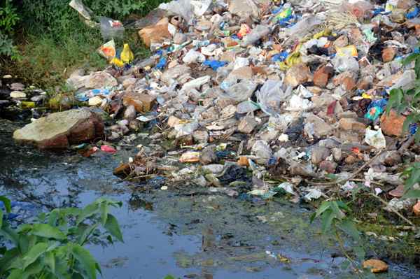 The refuse and rubbish of the town often gets discarded along the sides of the river bank.