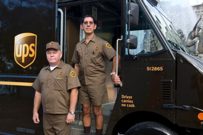 Does United Parcel Service really need two people to do a one-man or one-woman job? And, do they ever take off those shorts and get some long pants, even in the middle of winter?