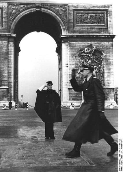 January 31, 1941. French policeman (wearing cape) exchanging salute with a German officer in front of the Arc de Triomphe