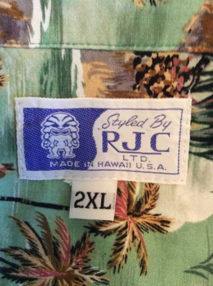 Styled by RJC, LTD, and made in Hawaii, with tropical fish, and pom trees blowing in the wind. It is a true classic Hawaiian shirt.