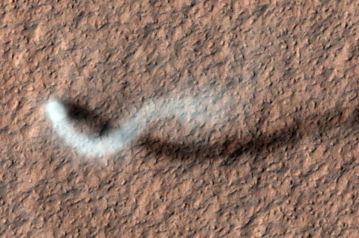 A dust devil casts a serpentine shadow over the Martian surface in this image acquired by the High Resolution Imaging Science Experiment camera on NASA's Mars Reconnaissance Orbiter.