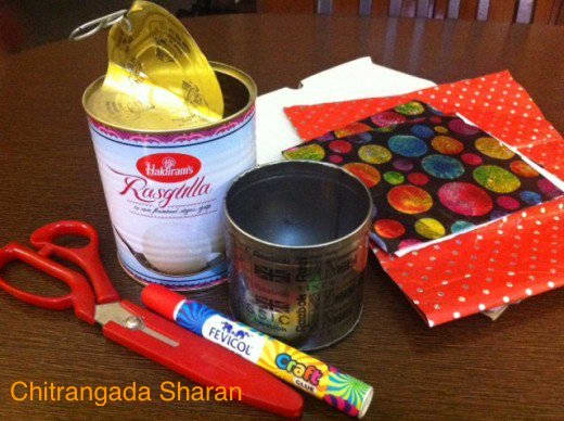 Used metal containers , used gift wrapping papers, scissors, glue/ Fevicol, used packing cardboard