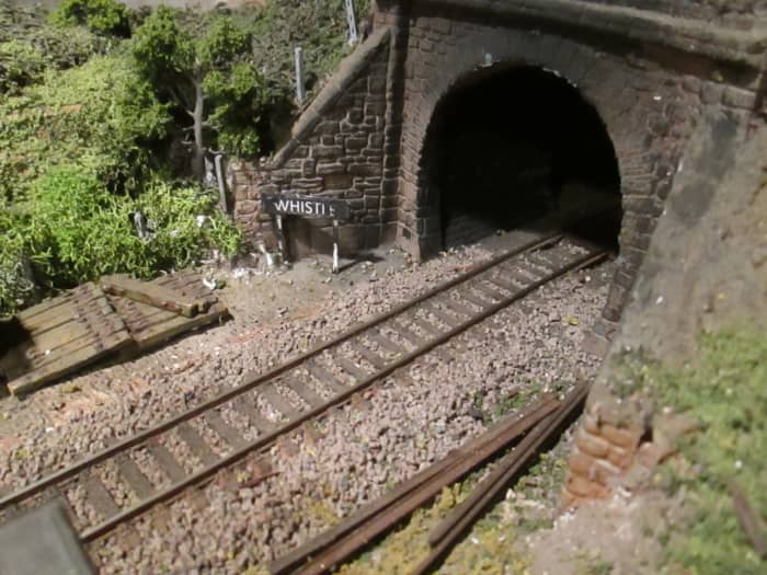 The 'boxed' tunnel mouth on the Ayton Row side of the main 'tunnel', ballasted track, rusted rails at the trackside, 'whistle' board, sleeper stack, fence posts and vegetation aplenty. Tunnel mouth blacked within to reinforce effect