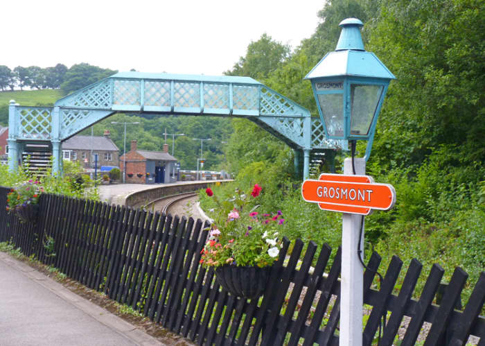 Grosmont, junction with Northern Rail branch to Whitby and North Yorkshire Moors Railway. Note detail touches, gas lamps with enamel name lozenge, footbridge, diagonally arranged platform fencing, brick open shelter on adjacent platform (distance)