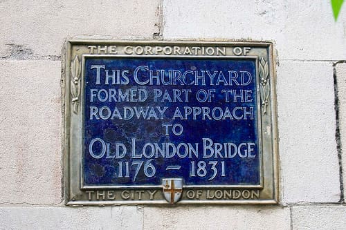 Early blue plaque marks the entrance through the churchyard of St Magnus the Martyr to the Old London Bridge of AD 1175-1831 when the predecessor to the modern London Bridge was built