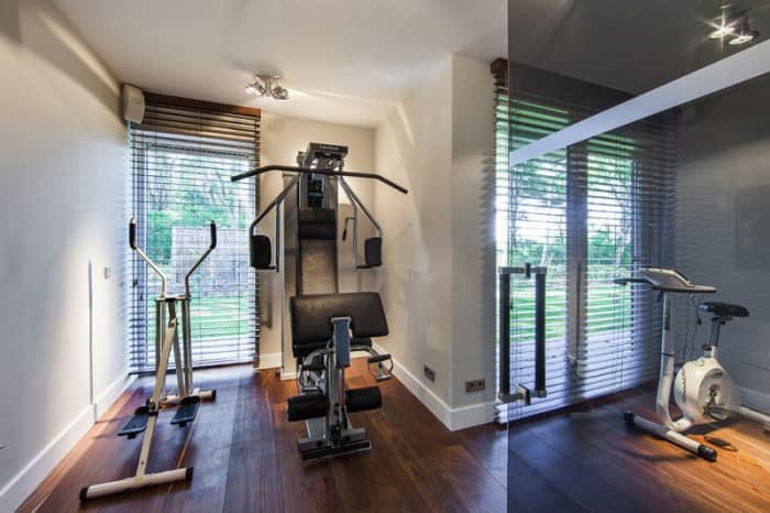 Wood Blinds and a Wood Floor in a Home Fitness Room Provide an Inviting Home Decor