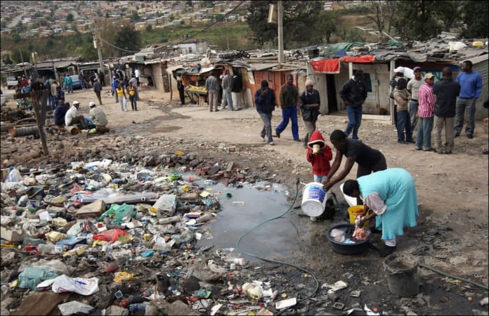 Squatter Camp Near Alexander Township In Johannesburg, and its inhabitants using a public water tap for everything