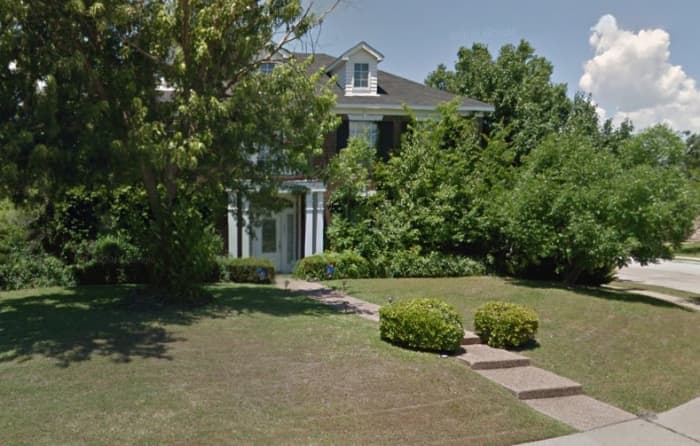 The house today. The current owners say sightseers still photograph the house to this day. Owners removed the fountain from the front yard and the spa from the back yard. They allowed the bushes to grow up over the windows for privacy.