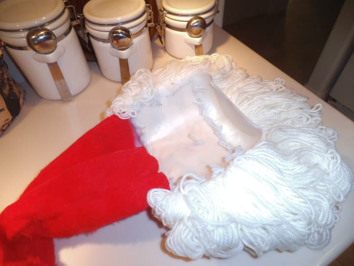 This view shows how the pipe cleaners are tied into the holes of the bleach bottle. This is how the yarn is attached for the beard. The part with the handle of the bleach bottle gets covered with the Santa hat.