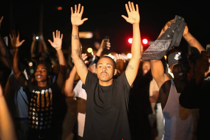 You can't tell in this photo if the man is lifting his hands in a worship service or at the command of a police office.
