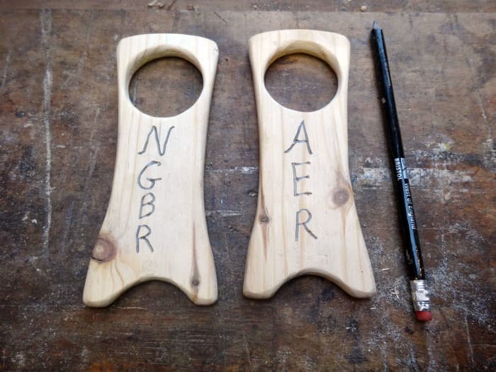 Inscribing our initials in the stands as a simple design; pressing hard with the pencil to indent the wood.