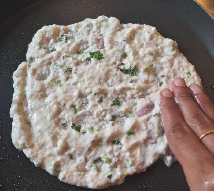 Spread batter uniformly on tawa using wet fingers. Keep the flame low to prevent from burning. Spread as thin as possible.