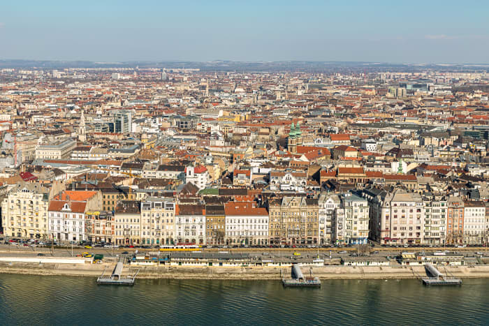 The landscape of Budapest. Budapest's total territory is 525 km² The city is divided into two parts by the Danube. The hilly left bank is called Buda, with over 20 hills within the territory of the capital, and the plain right bank is called Pest.