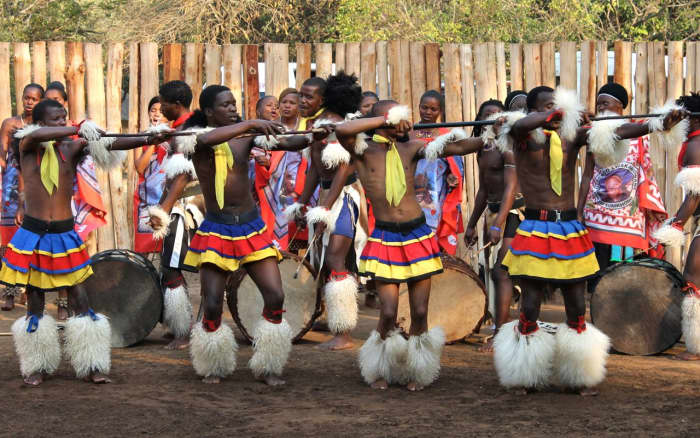 Swazi men doing their traditional dancing and singing, dressed in their cultural/traditional clothes