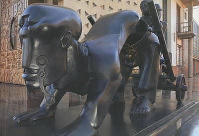 Feni Expressing The Burden that Africans Feel and being carried along with; He Carved this Stature artistically and spiritually expressing the sobering said reality that Africans themselves Are a best of Burn-Articstically/Sculpturally