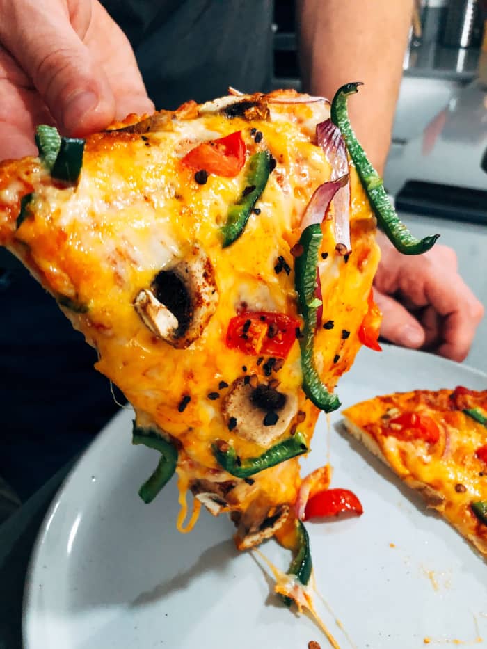 Homemade veggies pizza. We enjoy eating pizza while watching a show. I think everybody is doing that.