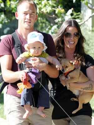 Alanis Morissette and Ever Treadway. Her husband is holding their child, while also wearing it.