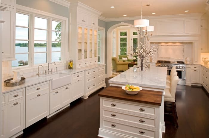 glass cabinet door add character to a classic white kitchen - accented with wood flooring and arched door ways