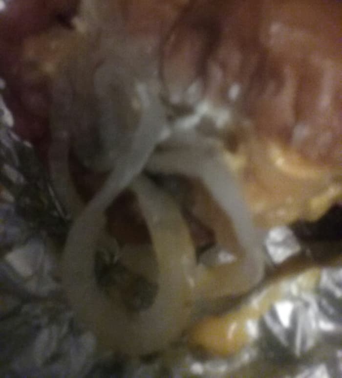 burger with various toppings including cheese and lots of grilled onion slices from Cook Out Fast Food Restaurant