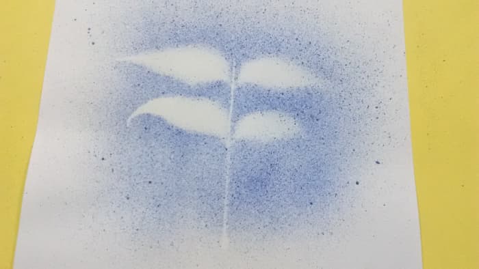 Once the spraying is finished, carefully remove the twig from the painting taking care not to smudge the tiny droplets with your hands.