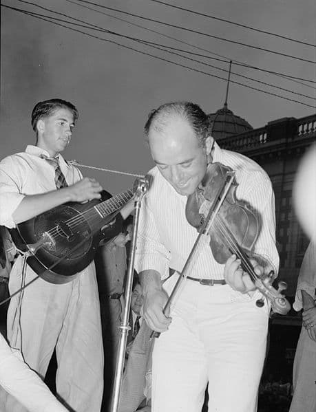 "Musicians in Cajun band contest, National Rice Festival, Crowley, Louisiana. Most of the music was of the folk variety accompanied by singing." 1938. Shown are musicians playing violin and steel guitar.