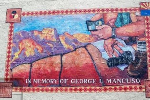 A mural in memory of a famous local photographer on the side of the Peace Surpluss building on Route 66