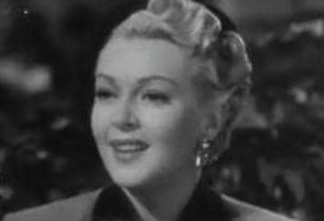 Lana Turner's round face is made more elegant by having her hair swept up and back.