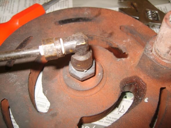 The oil feed pipe beneath the burner; it is a good precaution to remove and clean the oil feed pipe. This is located beneath the burner