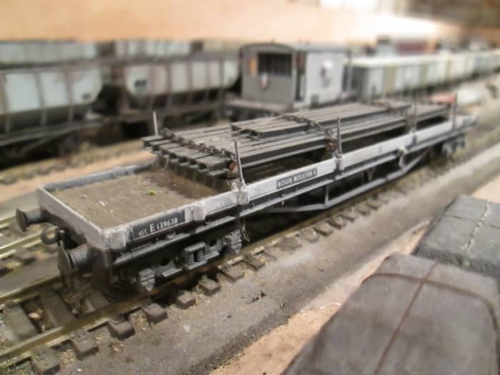 One of a trio of Bachmann ex-LMS Bogie Bolster wagons with chained square steel pipe load - one of two painted in early BR grey - see image top of page