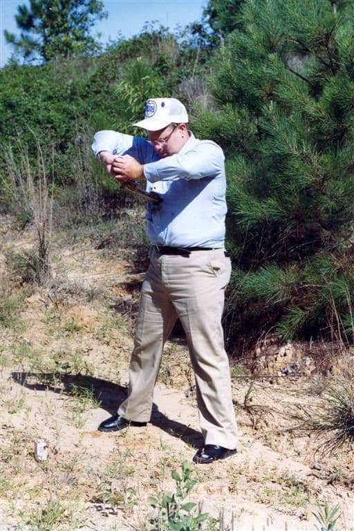 Richard Davis demonstrating his Second Chance Kevlar body armor by aiming a revolver at his own chest, circa 1991