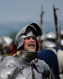 Armor on an re-enactor dressed as a medieval knight, note the full curved plates cover all spots, including throat and armpits.