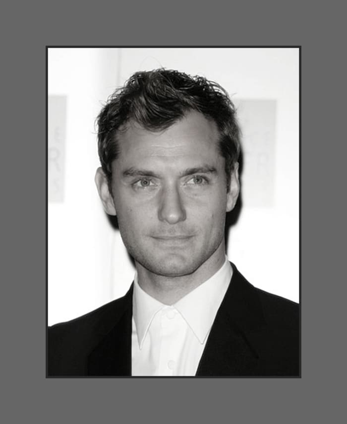 Jude Law's hair is cut in layers short on the side and longer in top and styled with a soft wave covering a little of the forehead - 2013 Hairstyles for Men with Balding Thinning Hair Style Cuts Trends