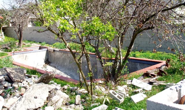 Small backyard pool under construction. After the pool is built, the owner will work with the landscape around it.