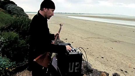 The Edge adjusts a vintage EHX Deluxe Memory Man pedal in a scene from the film "It Might Get Loud."