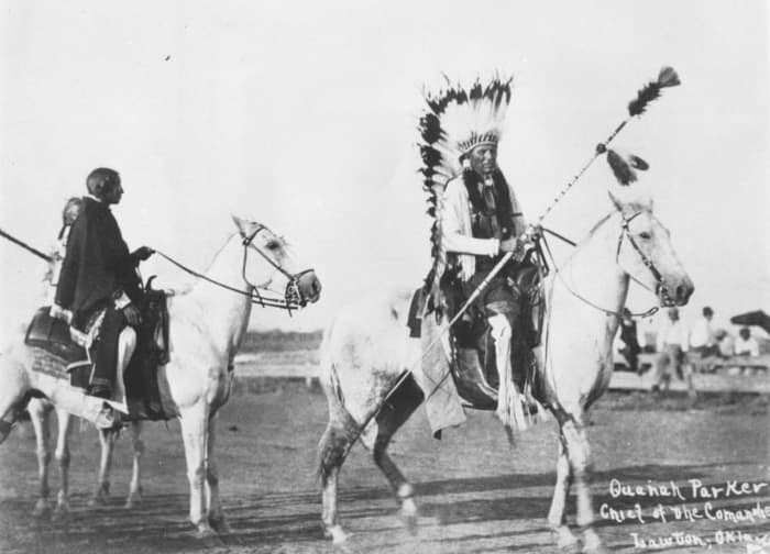 Quanah Parker in Lawton, Oklahoma. Date and photographer unknown. He is shown here wearing a headdress on horseback.