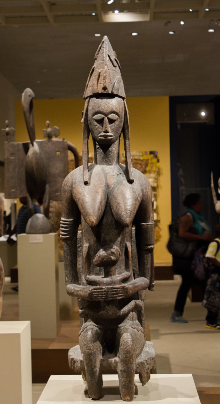 This African statue is of the primordial male, the first man. It shows him sitting tall and proud.