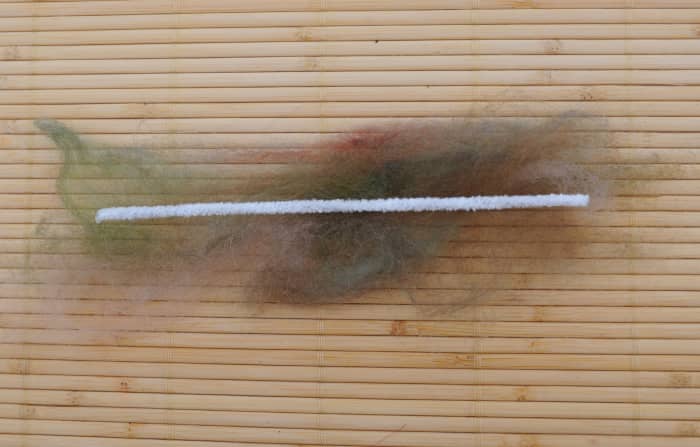 Place a cotton pipe cleaner on top of the thin layer of green fibers to make the stem