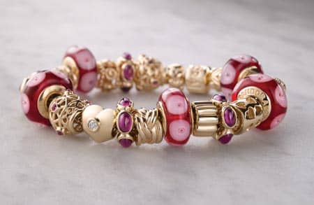 beautiful story book pink and fuscia and gold Pandora bracelet complete with intricate charms of hearts and murano glass