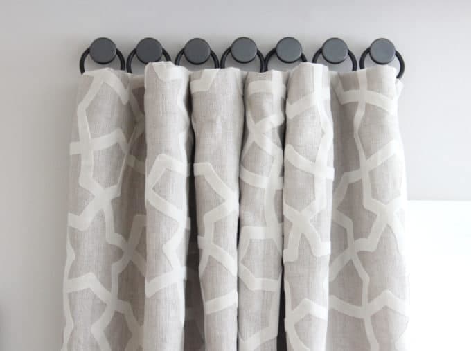 The rings sewn on the curtains and hang them on the cabinet knobs. Screw the knobs into the walls above the windows.